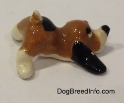 The right side of a Hound Dawg figurine that has long black ears laying on the ground.